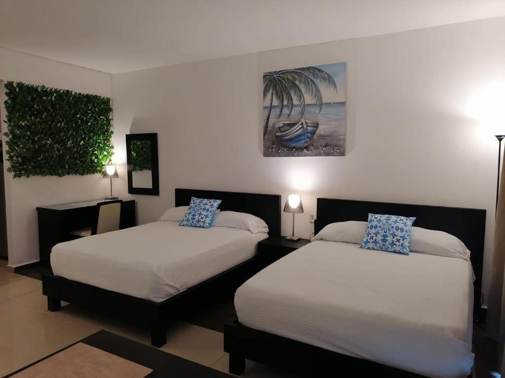 1 dormitorio con 2 camas y un cuadro en la pared en Playa Blanca SC, en Río Hato