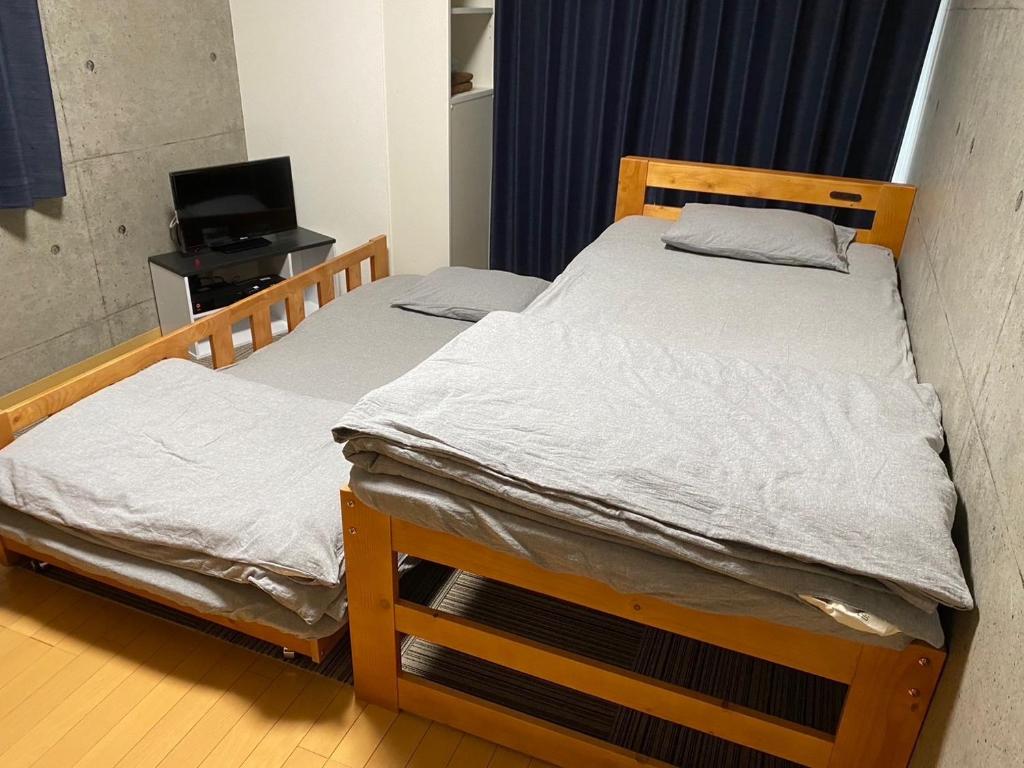 two twin beds in a room with a television at Marvelous Kokubunji - Vacation STAY 80468v in Kokubunji