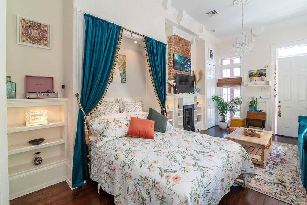 Schlafzimmer mit einem großen Bett und blauen Vorhängen in der Unterkunft Historic Victorian Studio Near City Park NOMA Bayou St John in New Orleans