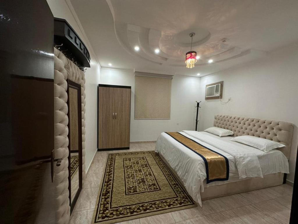 een slaapkamer met een groot bed en een tapijt bij شموع المروج للوحدات الفندقية in Tabuk