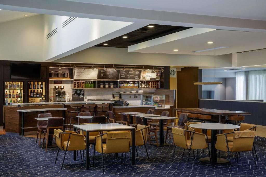 a restaurant with tables and chairs and a bar at Courtyard Denver Tech Center in Greenwood Village