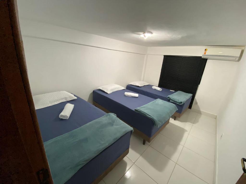 duas camas num pequeno quarto com lençóis azuis em THE BROTHERS em Angra dos Reis