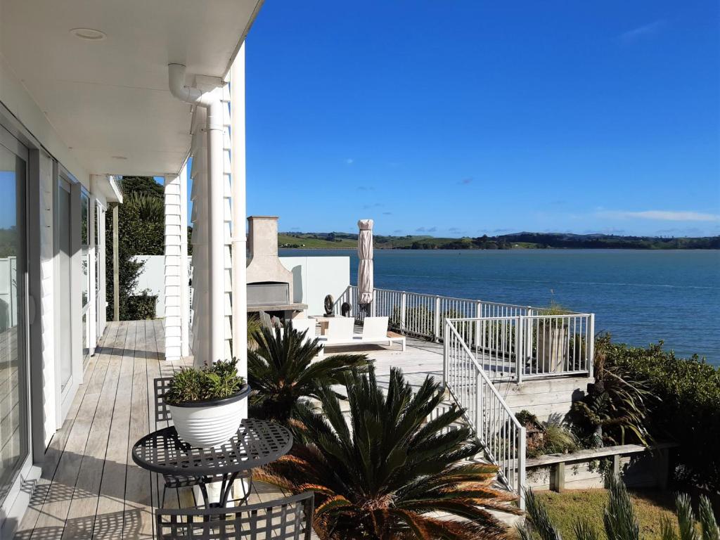 a porch of a house with a view of the water at Once Upon a Tide in Auckland