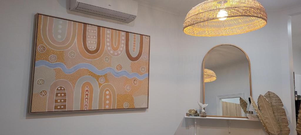 a bathroom with a large painting on the wall and a mirror at Boutique Beach House in the HEART of St. Kilda in Melbourne