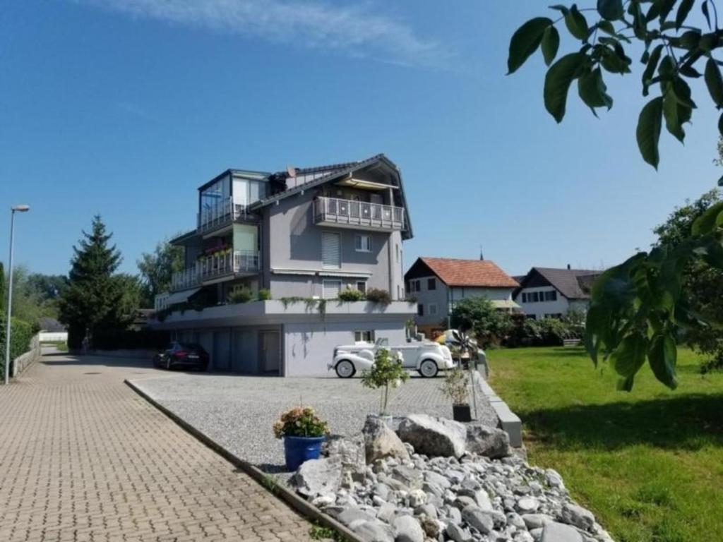ein großes Haus mit einem davor geparkt in der Unterkunft Schönes Studio direkt am Bodensee in Altenrhein