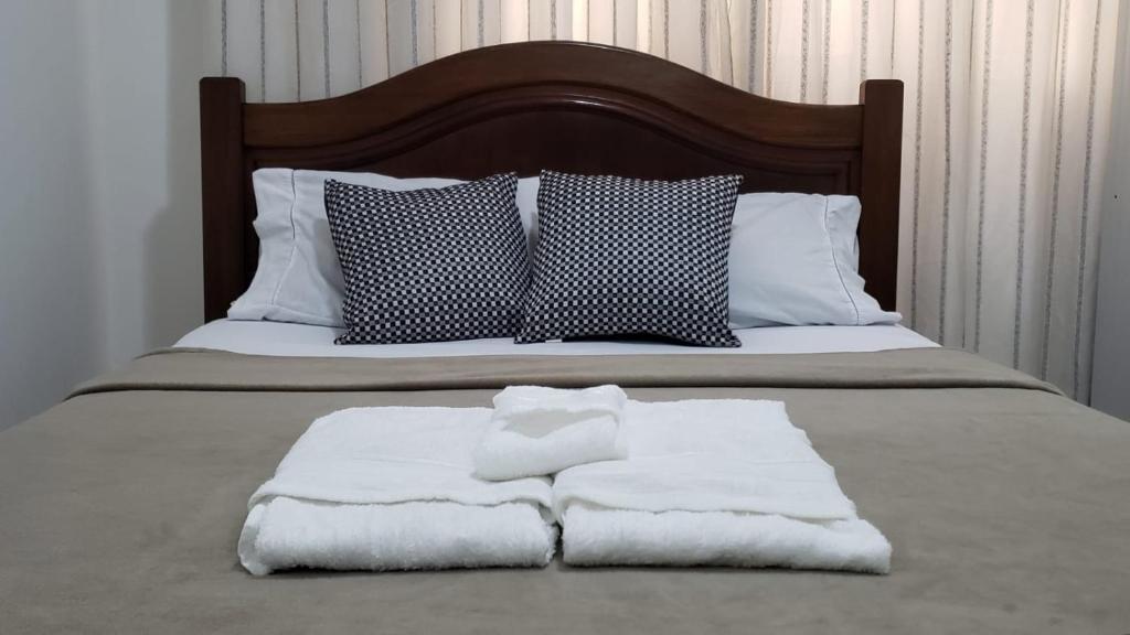 Una cama con dos toallas encima. en Loft Aconchegante Centro Niterói / RJ Inter 300Mb en Niterói