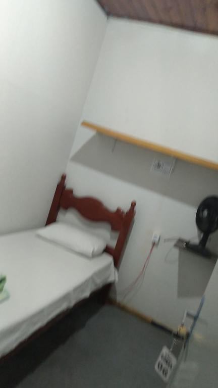a small room with a bed and a desk at Hostel Gomes in Sao Paulo