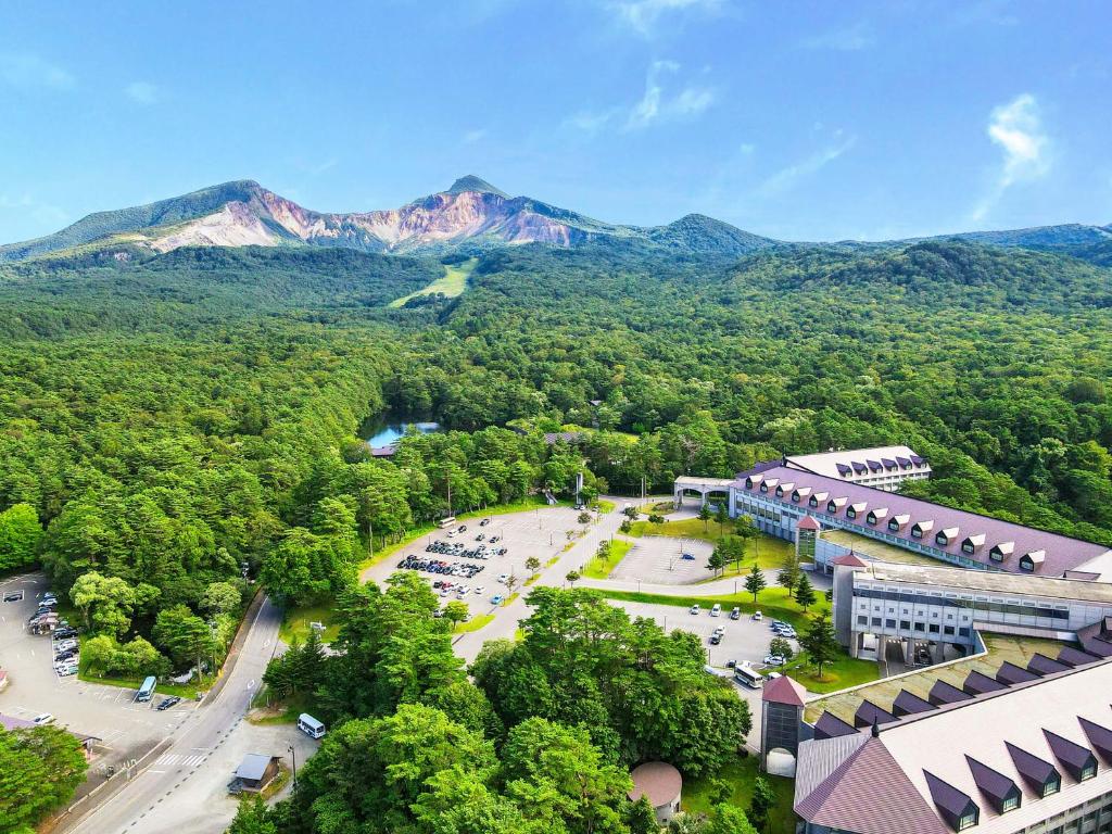 uma vista aérea de um resort com montanhas ao fundo em Urabandai Lake Resort Goshiki no Mori em Kitashiobara