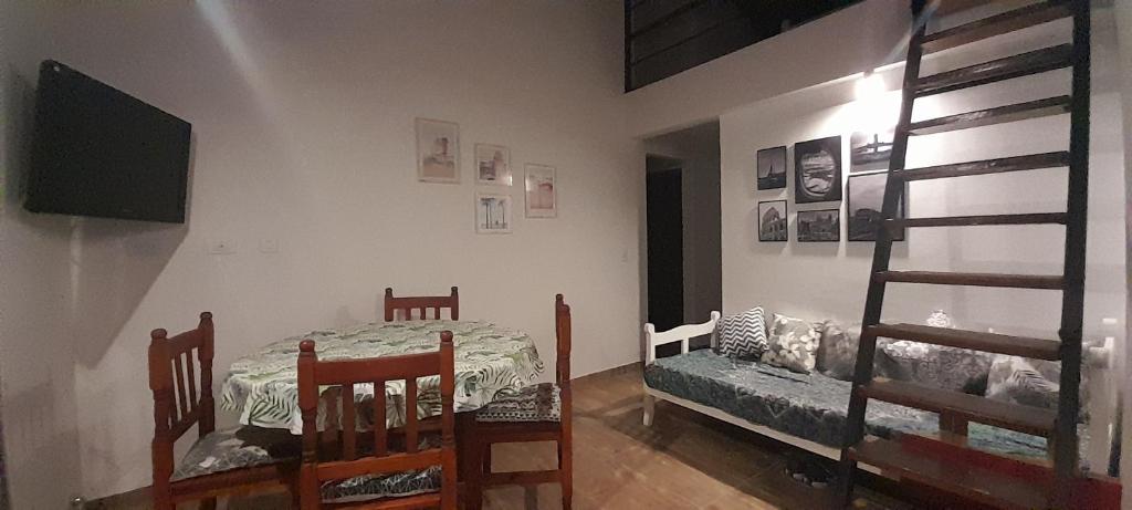 um quarto com uma mesa e cadeiras e um beliche em Dept. Miramar (1 cuadra del mar y 3 de SanBer.) em Costa Azul