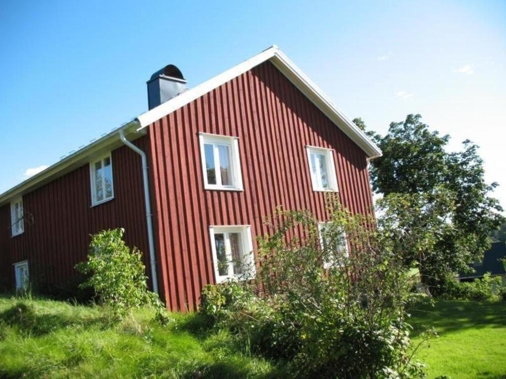 ein rotes Haus mit einem Kamin darüber in der Unterkunft Ferienhaus für 0 Personen 12 Kinder in Högsäter, Südschweden Dalsland in Högsäter