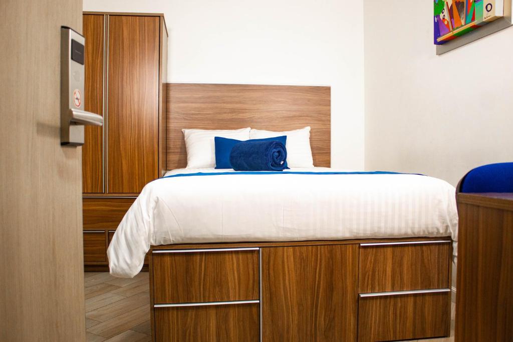1 dormitorio con 1 cama grande y cabecero de madera en La Casa Azul (Zona de Hospitales), en Ciudad de México