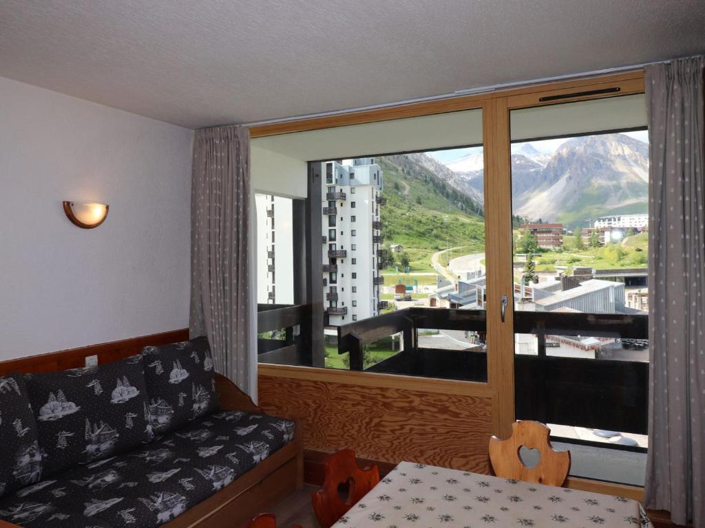 un salon avec un canapé et une grande fenêtre dans l'établissement Studio lumineux avec balcon, proche pistes et commerces, 4 couchages, animaux acceptés - FR-1-502-515, à Tignes