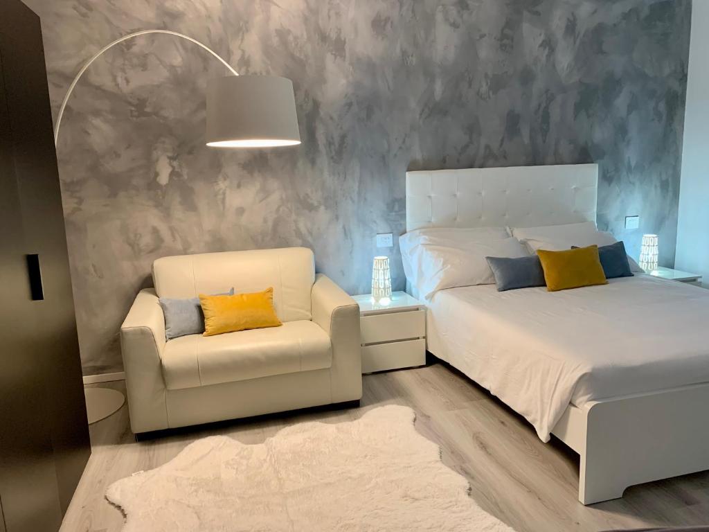 - une chambre avec un lit blanc et une chaise dans l'établissement Villa Carlotta, à Salionze
