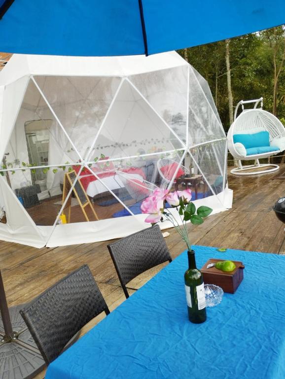 a tent with a table with a vase of flowers at Glamping Eco Azulejo in Arbeláez