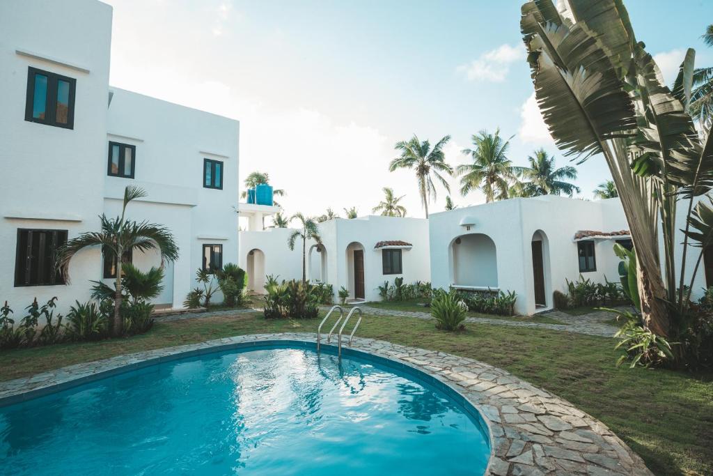 a villa with a swimming pool in front of a building at Hostel Bajala Siargao in General Luna