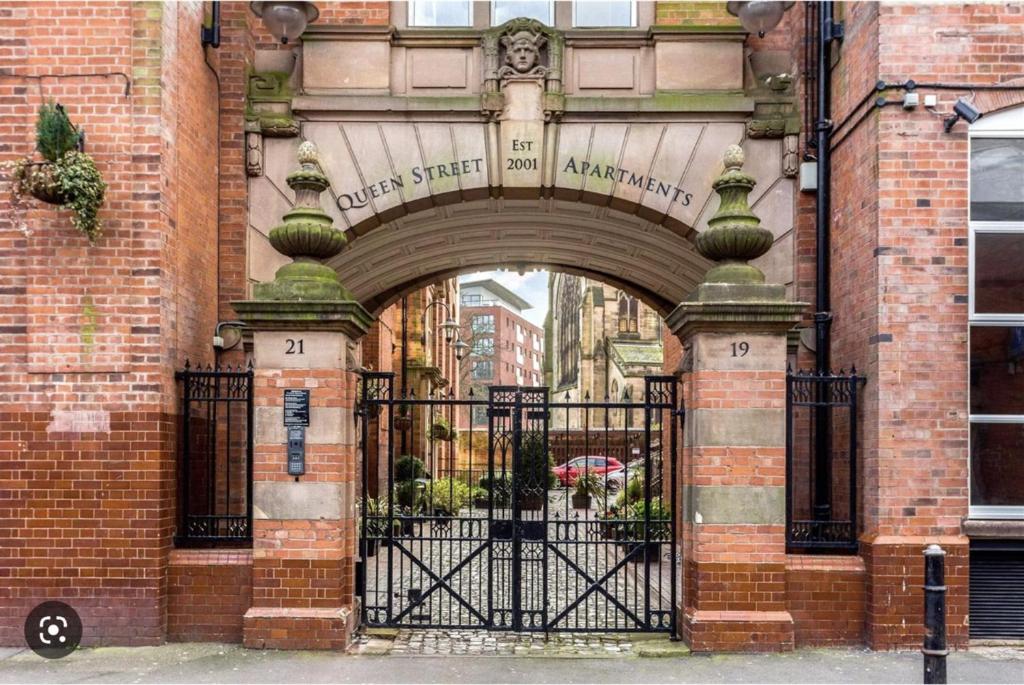 wejście do ceglanego budynku z żelazną bramą w obiekcie Luxury Stay with Sauna Gym and Pool in Leicester w mieście Leicester
