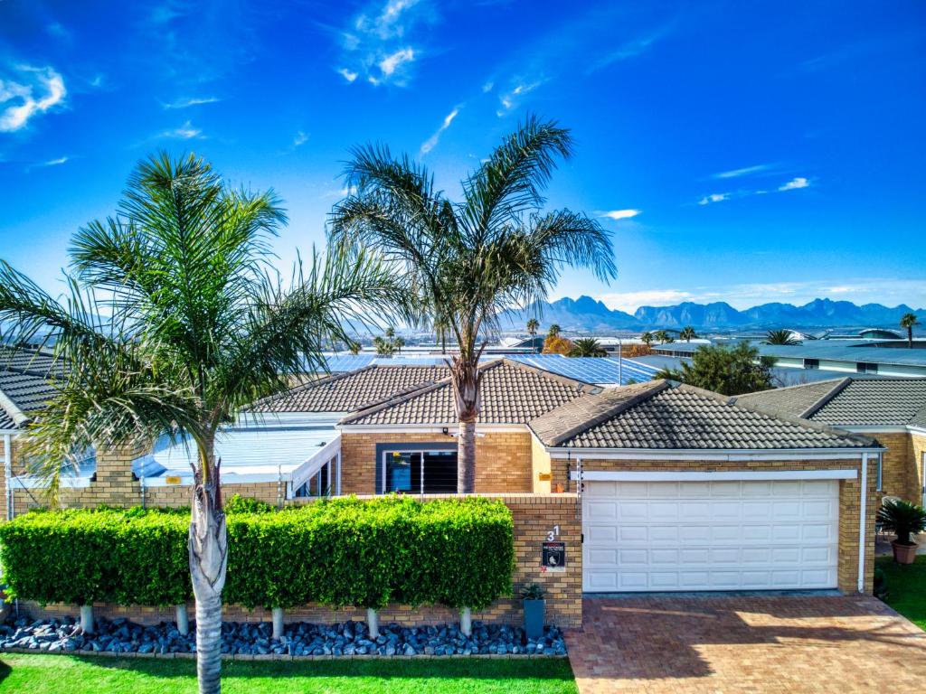 uma casa com palmeiras e uma garagem em Magnificent Villa Load-Shedding Free! na Cidade do Cabo