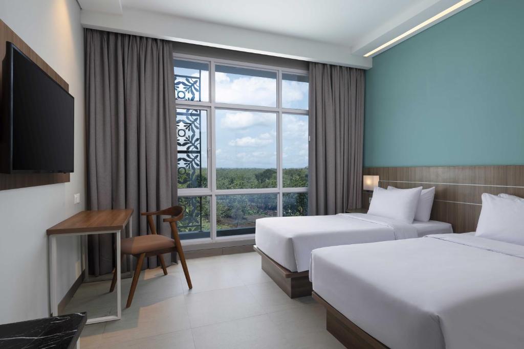 Postel nebo postele na pokoji v ubytování Hotel Santika Gunungkidul