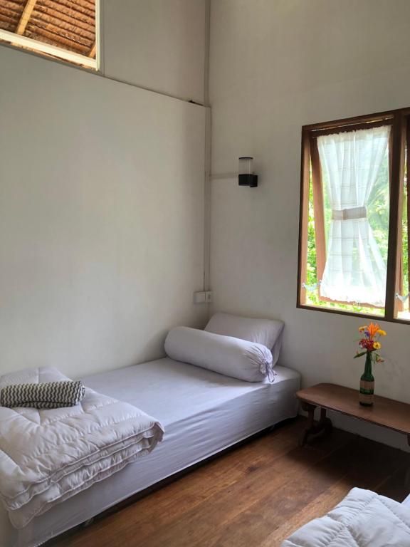 a small room with a bed and a window at Villa Beach Mentawai in Katiet