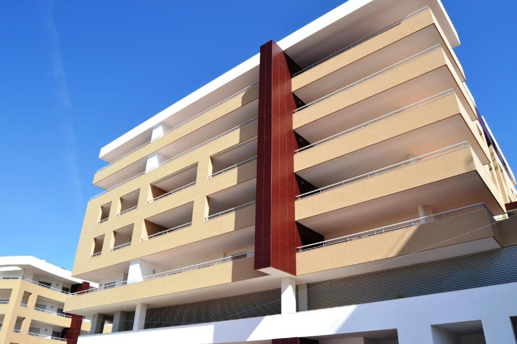 an apartment building with balconies against a blue sky at Santo Amaro Apartments in Lagos