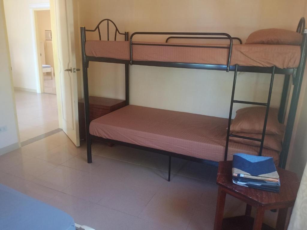 a room with two bunk beds and a table at Room in Lobo Triple N Home stay 1st N in Lobo