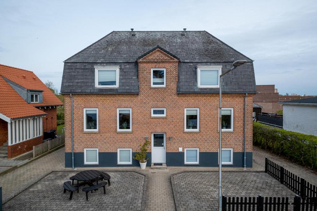 a brick house with a bench in front of it at Newly renovated 1-Bed Apartment in Aalborg in Aalborg