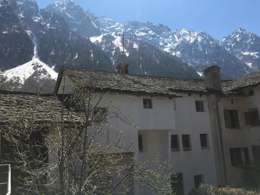 a building with snow covered mountains in the background at Ferienwohnung in Vicosoprano in Vicosoprano