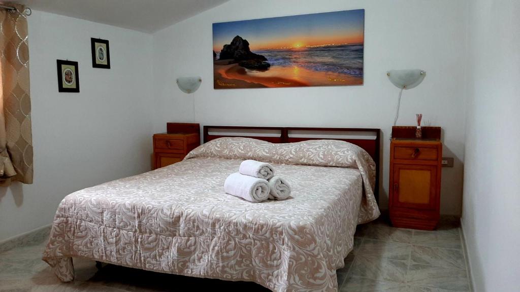 1 dormitorio con 1 cama con 2 toallas en A cà du Sepino a due passi dal mare en Carloforte