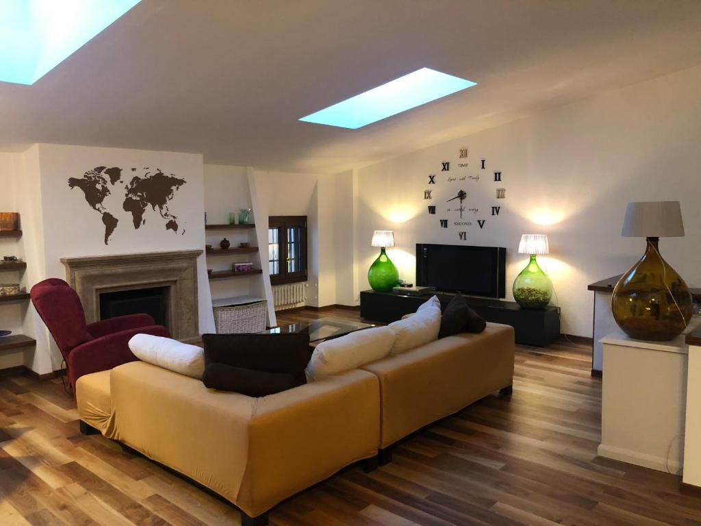 uma sala de estar com um sofá e uma televisão em Frane House em Lazise