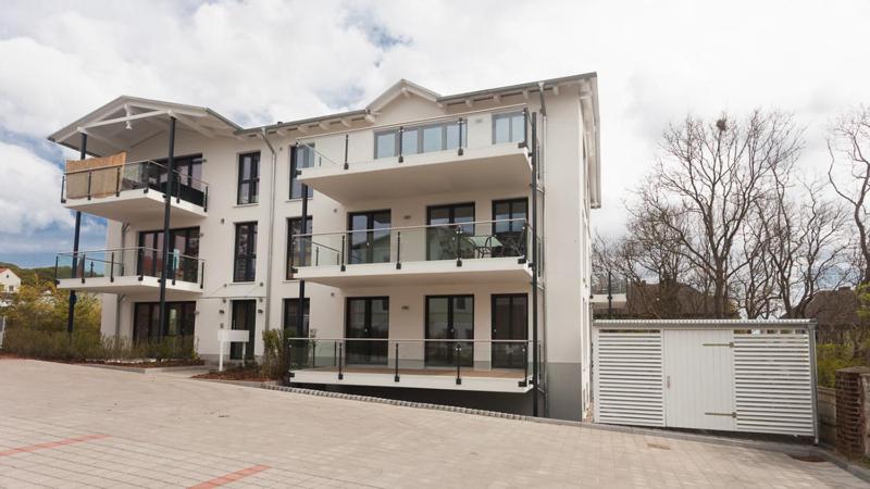 a white building with a garage in front of it at Stella in der Villa Amelie am Meer in Sassnitz