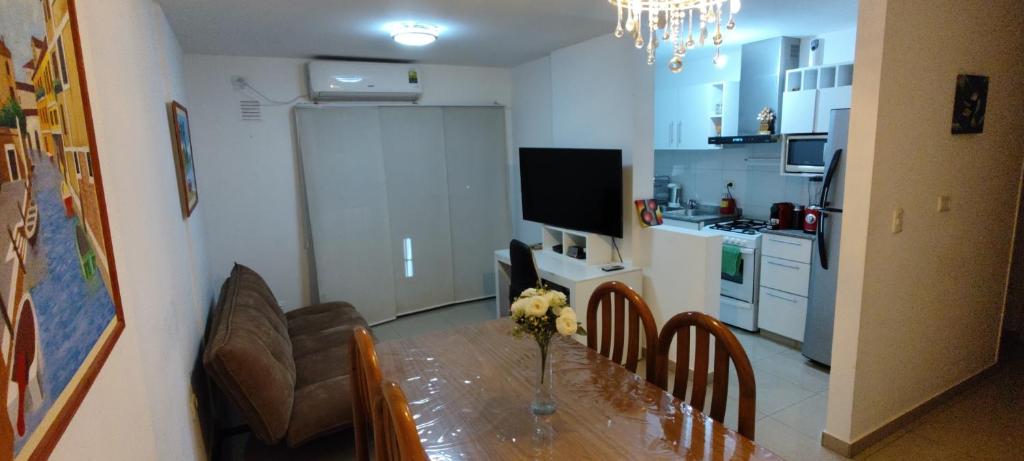 a kitchen with a dining table and a kitchen with a refrigerator at Departamento Alta Cordoba "Lautaro", con Pileta in Cordoba