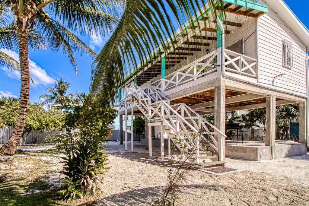 a house with a staircase on the side of it at DV 3 at DV Cabanas Gold Standard Certified in Caye Caulker