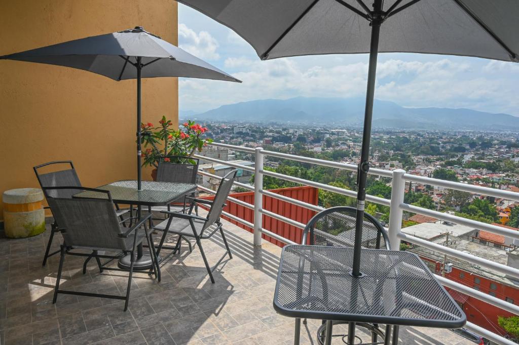 a balcony with tables and chairs and an umbrella at Casa LEONOR in Oaxaca City