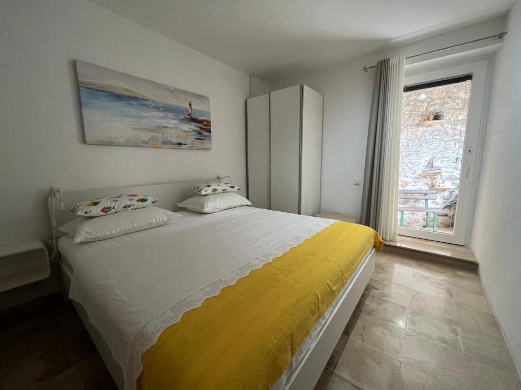 ein Schlafzimmer mit einem großen Bett und einer gelben Decke in der Unterkunft Apartment Get in Supetar