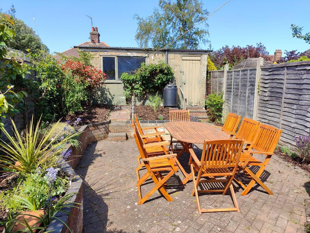 a wooden table and chairs in a garden at 2 bed 4ppl, Ground &1st Floor, 2x parking spaces, The Halt in Sheringham