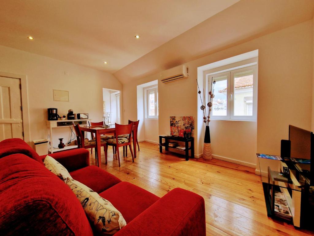 un soggiorno con divano rosso e tavolo di Mouraria Studios & Flats by Lisbon Village Apartments a Lisbona