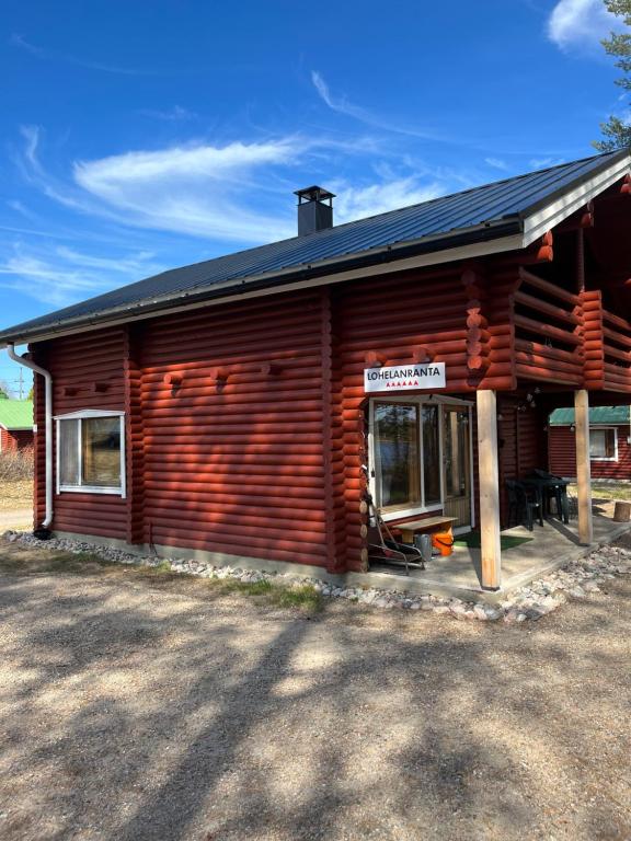 una cabaña de madera con un cartel en la parte delantera en Lohelanranta, en Kemijärvi