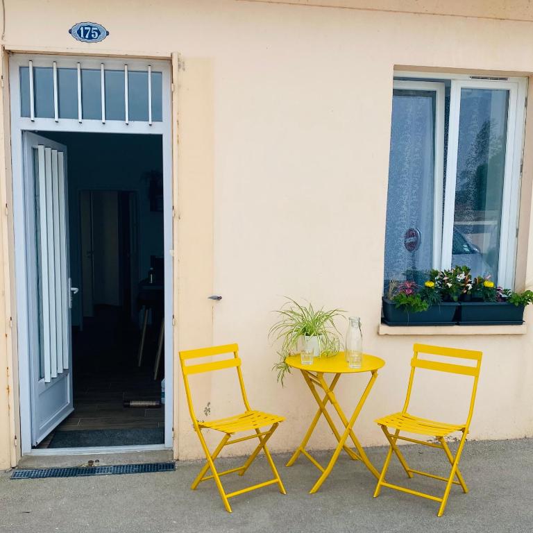 two chairs and a table in front of a building at L’escale 175 in Divatte sur Loire