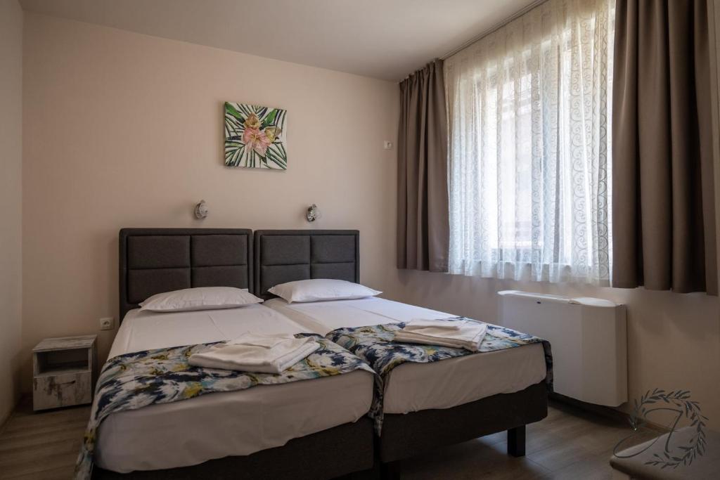 a bedroom with a bed and a large window at Апартаменти и Студиа Алекса Созопол Apartments and Studios Alexa Sozopol in Sozopol