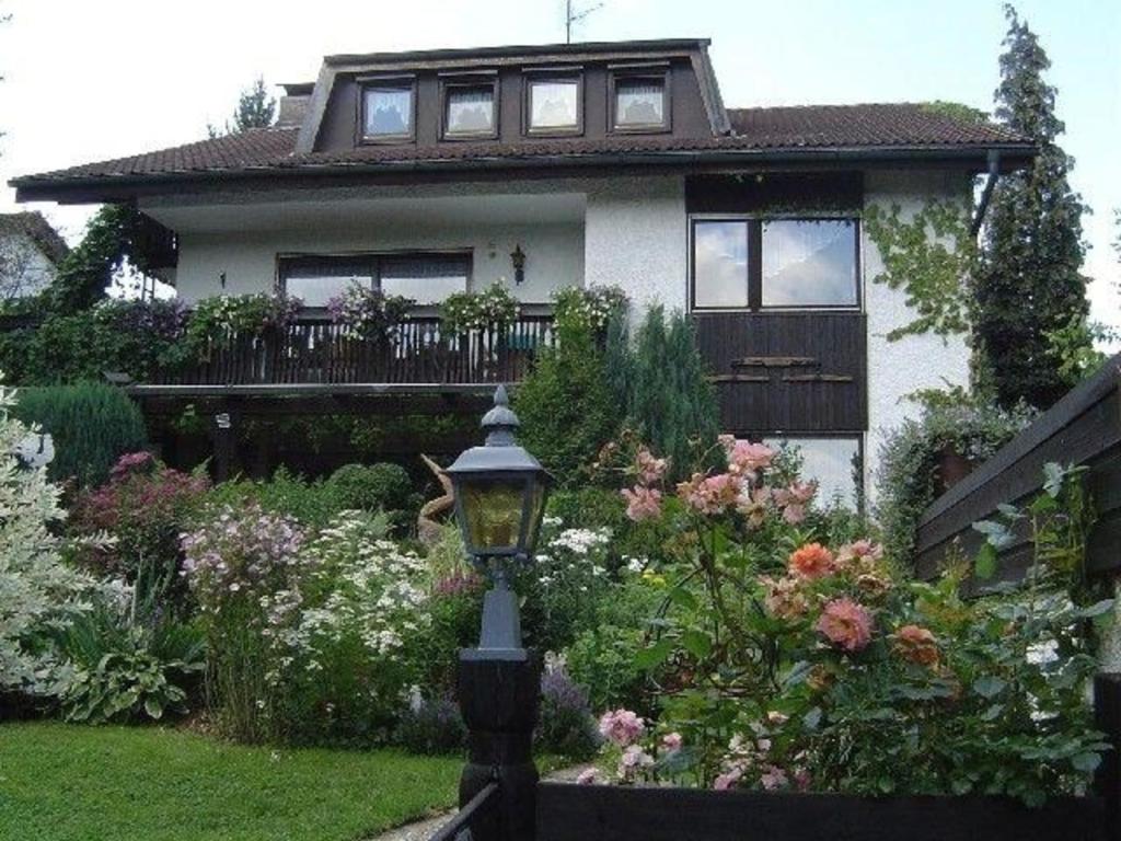 a house with a street light in front of a garden at Großzügige Ferienwohnung für 5 Personen mit überdachter Terrasse und wundervollem Garten mit Koi-Teich in Waldnähe in Marktredwitz