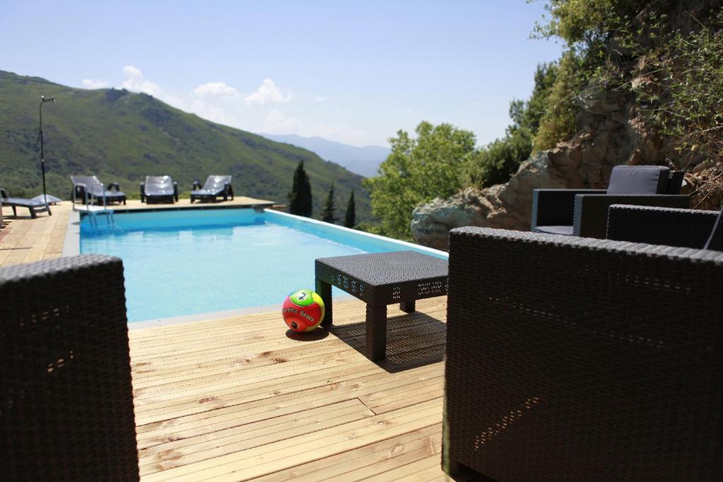 - une piscine avec une table et un ballon de football sur une terrasse en bois dans l'établissement Casa U Panurama, à Barbaggio