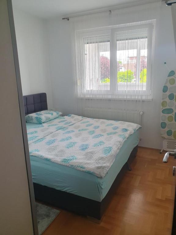 a bedroom with a bed in a room with a window at Apartman Džakula in Zagreb