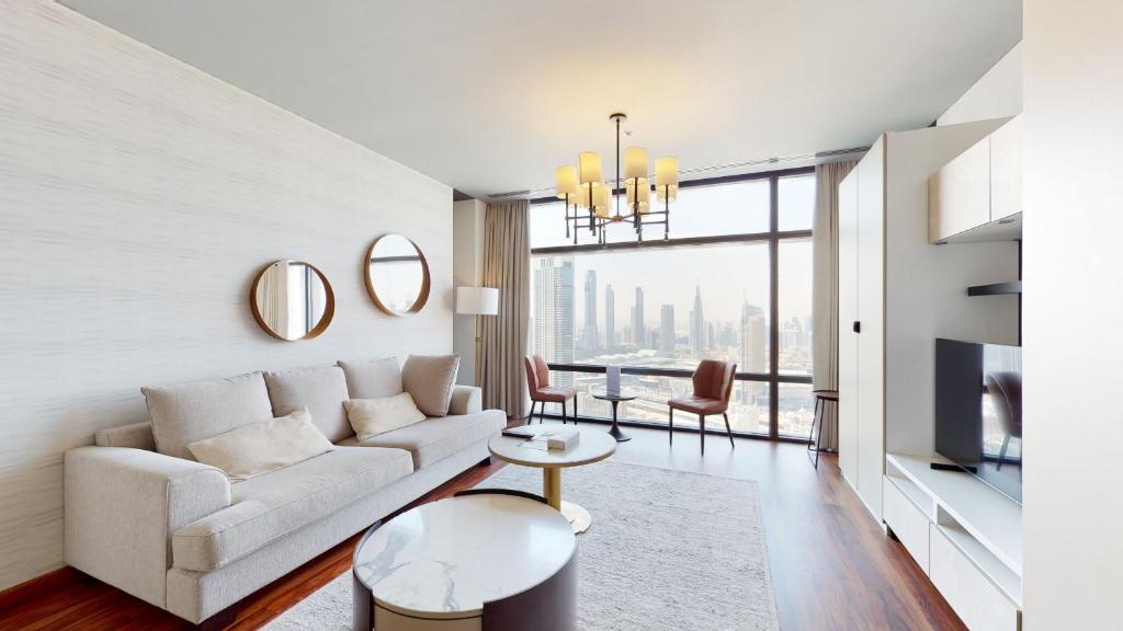a living room with a white couch and a large window at Primestay - Index Tower 1Br in DIFC in Dubai