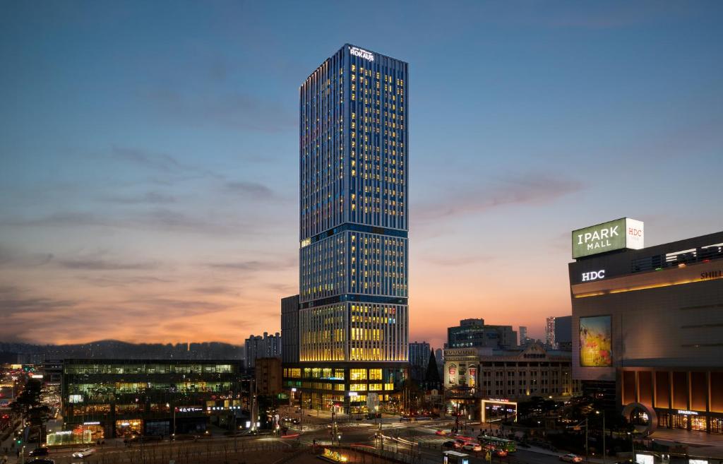 a tall building in a city at night at Nine Tree Premier ROKAUS Hotel Seoul Yongsan in Seoul