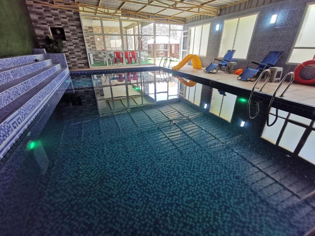 a swimming pool with a bench in a building at Villa Salassel Al Jabal Al Akhdar فلة سلاسل الجبل الأخضر in Al ‘Ayn