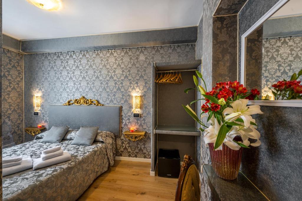 Hotel Apostoli Garden في البندقية: غرفة نوم مع سرير وورود على الحائط