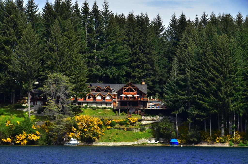 a large house on the shore of a lake at Dos Bahias Lake Resort in Villa La Angostura