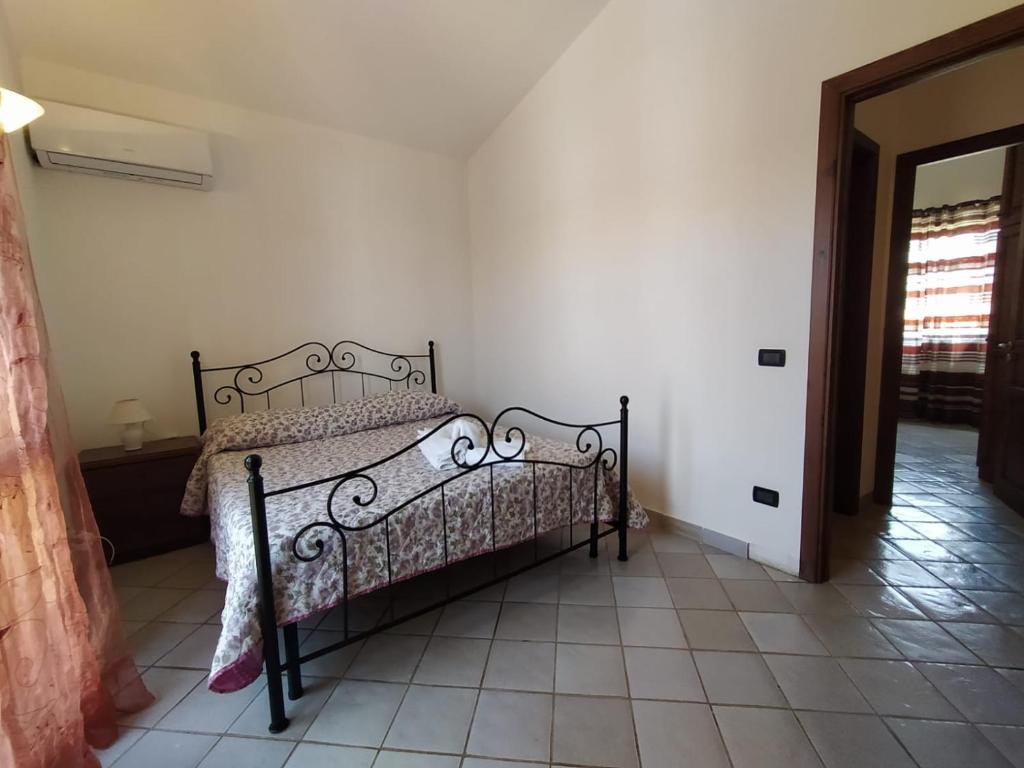 a bedroom with a bed and a tiled floor at SanVitoTour- Residence Il Baglio in San Vito lo Capo