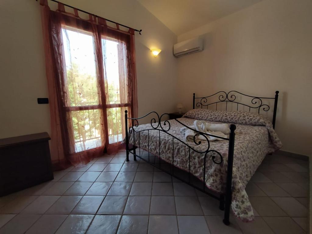 a bedroom with a bed and a large window at SanVitoTour- Residence Il Baglio in San Vito lo Capo