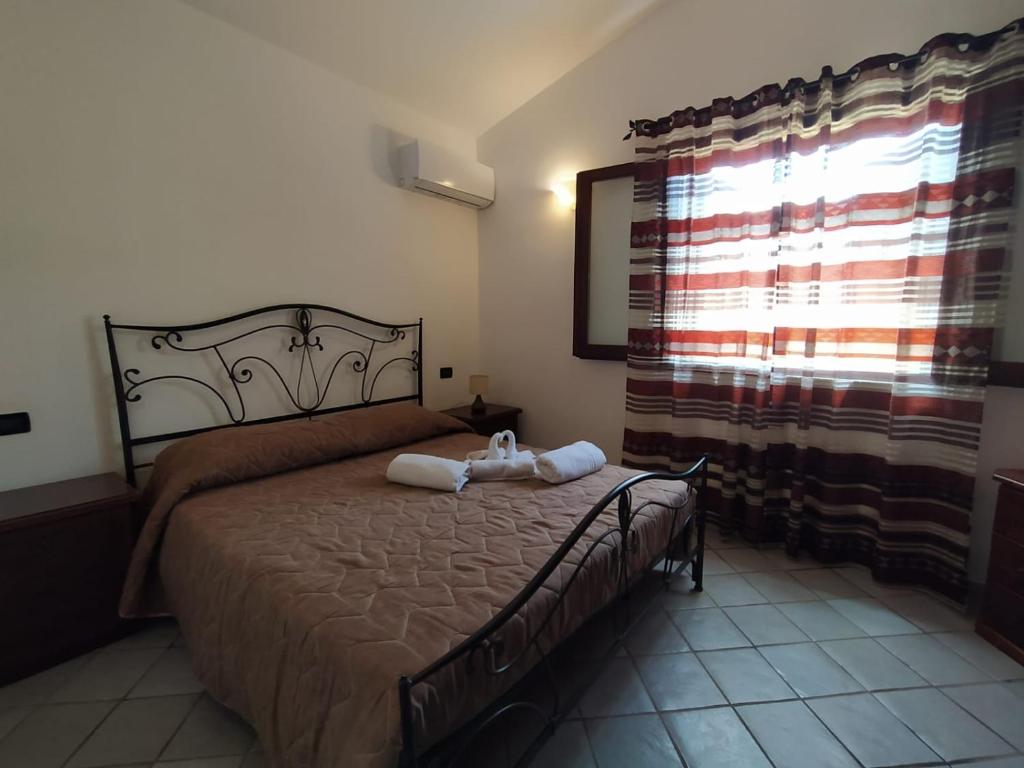 a bedroom with a bed with two towels on it at SanVitoTour- Residence Il Baglio in San Vito lo Capo